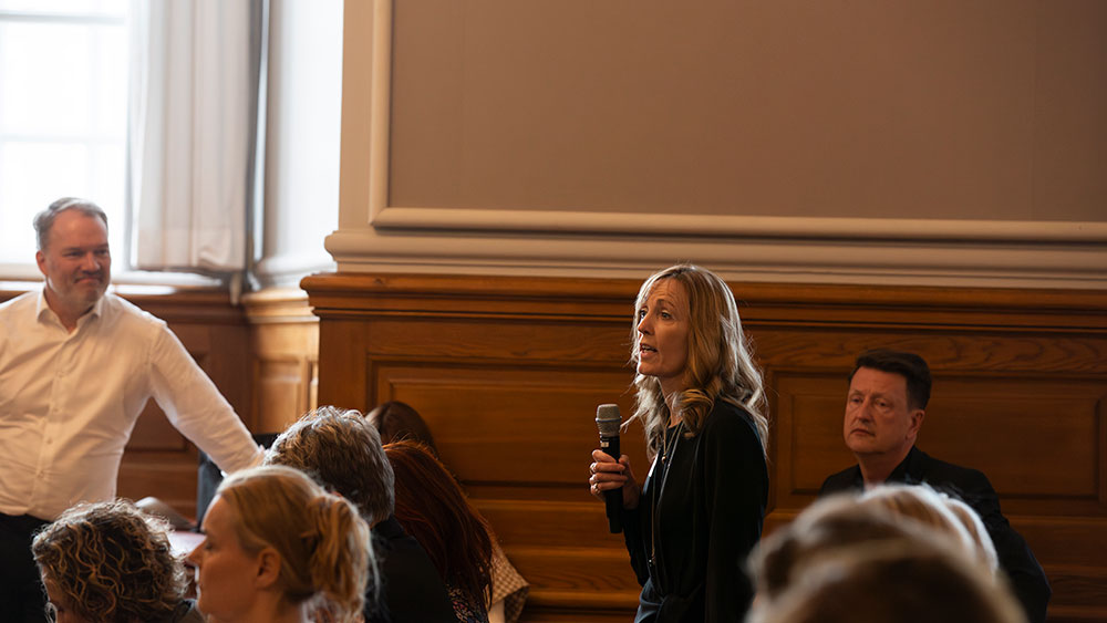 En kvinde stiller spørgsmål under en konference på Christiansborg.
